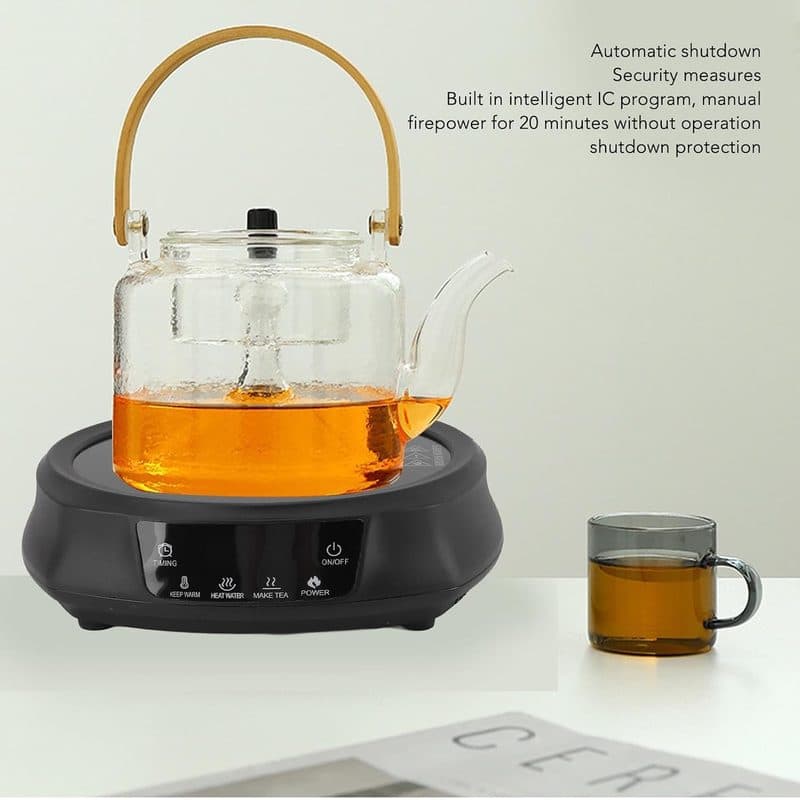 Tetera de vidrio con té sobre la estufa eléctrica Pomya junto a una taza de té